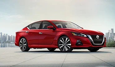 2023 Nissan Altima in red with city in background illustrating last year's 2022 model in Mathews Nissan of Paris in Paris TX