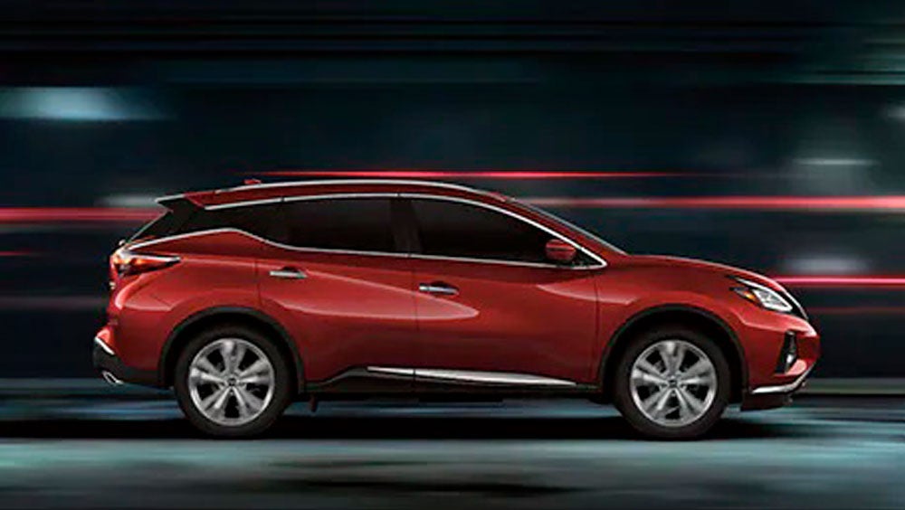 2023 Nissan Murano shown in profile driving down a street at night illustrating performance. | Mathews Nissan of Paris in Paris TX